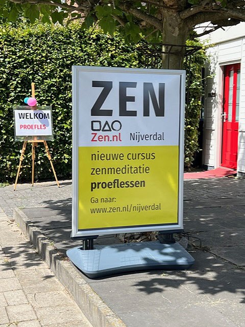 op het stoepje voor de zendo in Nijverdal staat een wit gele poster met daarop een aankondiging voor de nieuwe cursus en proefles zenmeditatie